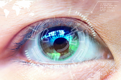The image shows a close-up view of a human eye with a digital overlay, including electronic circuit patterns and a world map, suggesting advanced technology integration into the eye.