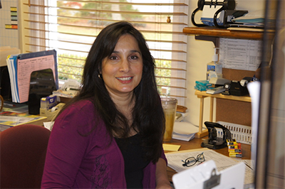 A woman sitting at a desk in an office environment.