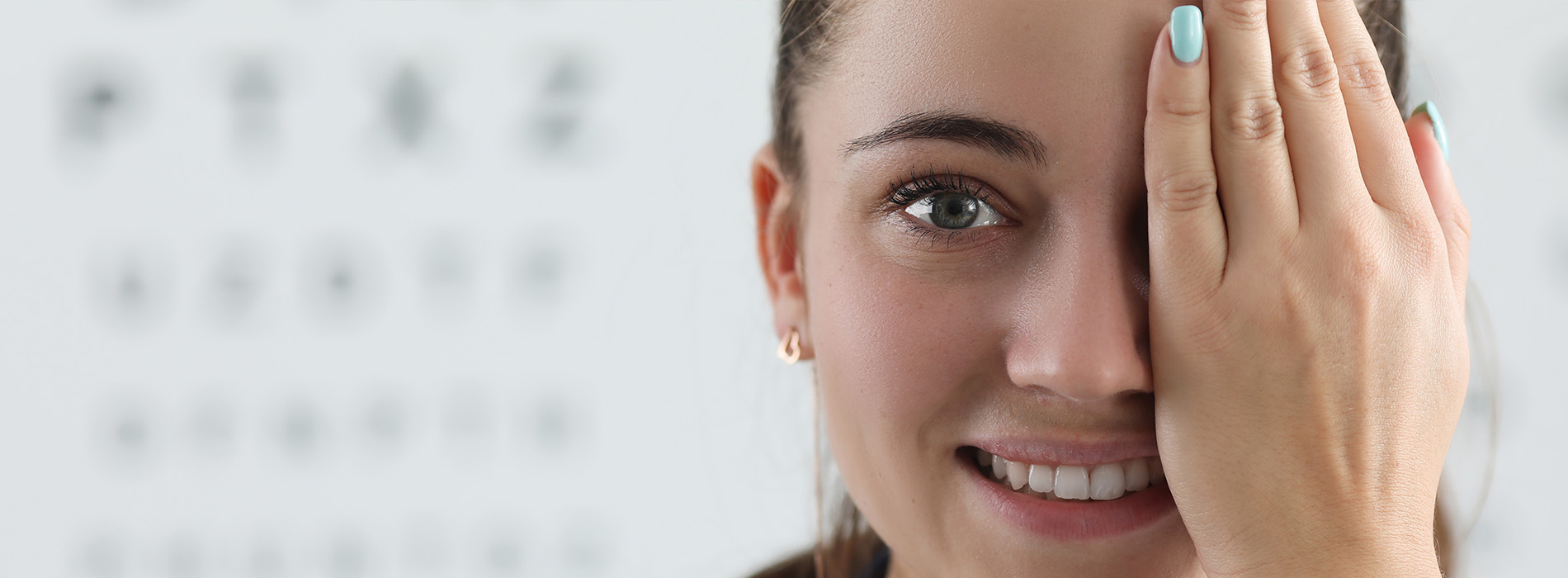 The image shows a young woman with her hand on her face, appearing to be examining her eyesight with an eye chart behind her.