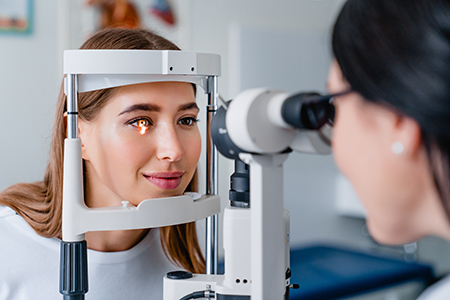 A woman having her eyes checked by an optometrist using an eye machine.